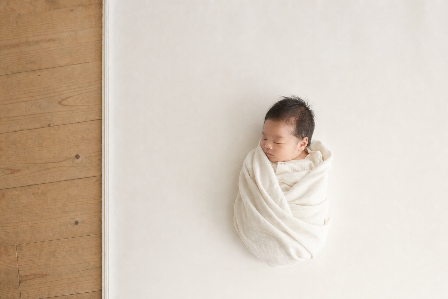 白いブランケットにくるまれて眠る赤ちゃん（掲載イメージ）