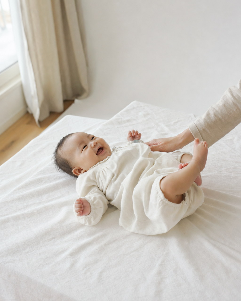 白いシーツの上で手足を動かす赤ちゃん(掲載イメージ)